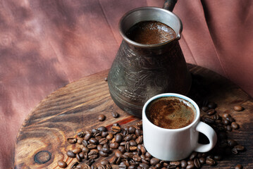 Coffee in cezve and white cup on a red background