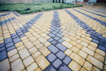 Nested pavers of various colors, around the grass is green, chic garden
