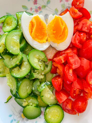 Uovo sodo con zucchine bollite e pomodori all'insalata