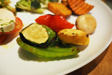 zucchini and sweet pepper grilled on a white plate close