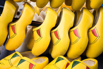 Traditional yellow painted wooden shoes from the Netherlands for sale in rows - Powered by Adobe