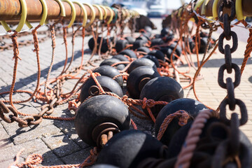 Bobbins and floats for bottom trawling with a trawl fishing net, drying on a street in a harbor in Urk, the Netherlands - obrazy, fototapety, plakaty