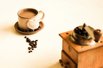 Cup of coffee with milk, coffee milk and mocha teapot on the white table. Warm color tones.