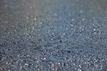 Wet asphalt background texture. Shallow depth of field