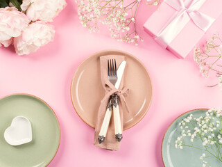 Pink flat lay with peonies decor flowers and pastel tableware. Festive occasion spring summer table setting
