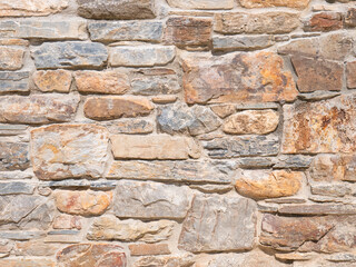 Natural stone wall of stones of different sizes forming an abstract background
