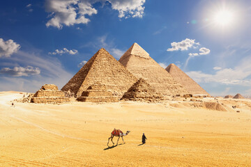 Famous Pyramids of Egypt and a bedouin with a camel, Giza, Cairo