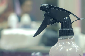 Sprayer with water on blur background in barbershop, closeup view. Professional equipment for...