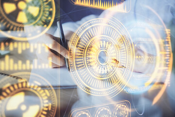 Fototapeta premium Tech theme hologram over woman's hands taking notes background. Concept of hightech. Double exposure