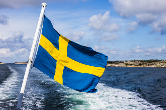 The Swedish flag flying in the wind on a boat cruising the Swedish archipelago, Sweden