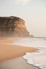 Photo of a beach in Portugal with a cliff in the back