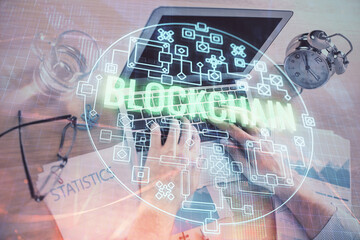 Blockchain theme hologram with man working on computer on background. Concept of crypto chain. Double exposure.