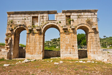 Fototapeta na wymiar Ruins of city gate near the road to arheological site of ancient Lycian city of Patara, Lycia, Turkey