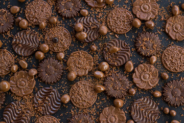 Milky and bitter round shape chocolate Madlen,designed on black background with ball chocolate and grains