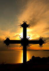 Iron cross with monastery in the bottom right in the sunset on Mount Athos, Greece 