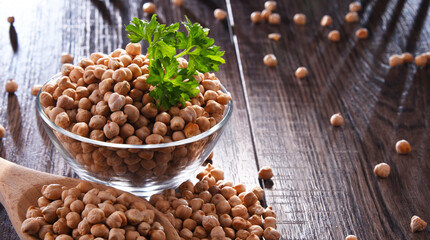 Composition with bowl of chickpeas on wooden table