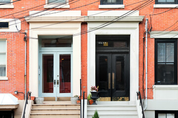 Two vintage shabby-looking entry doors in New York decorated with moldings. USA.