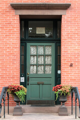 Fototapeta na wymiar Green vintage entry door in New York decorated with molding. USA.