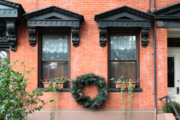 Black vintage windows decorated with corbels and wreath. New York. USA.