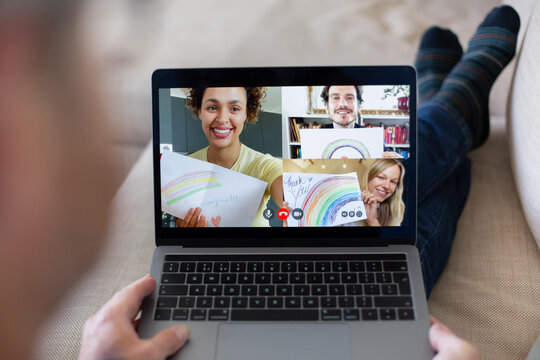 Friends holding drawings of rainbows on video call