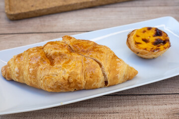 Croissant e pastel de nata numa mesa de esplanada