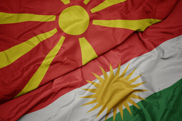 waving colorful flag of kurdistan and national flag of macedonia.