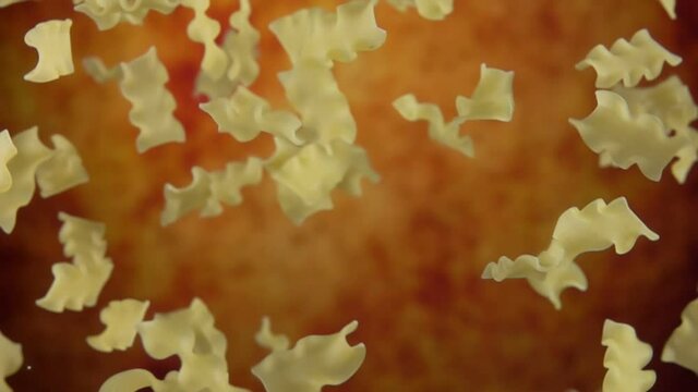 Pasta mafalde corte is flying up on a yellow ochre background in slow motion