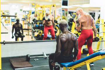 People from different generation and ethnicities doing workout sessions inside gym club - Fitness, healthy lifestyle and sport concept - Main focus on black man head