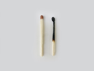 one whole and one burned match on a white background