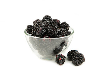 Ripe blackberry in a glass bowl isolated on white background.