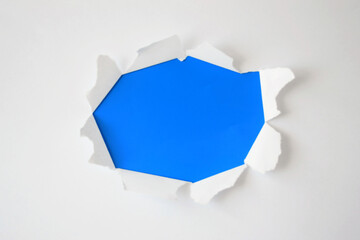 Ripped paper hole with torn sides over blue background for your text. Templets for advertising, print or promotional content.