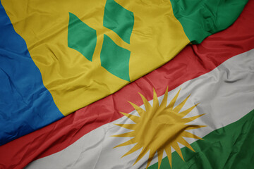 waving colorful flag of kurdistan and national flag of saint vincent and the grenadines.
