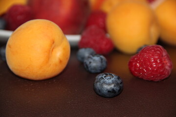 Fruit and berry plate on a dark background. Juicy summer berries and fruits