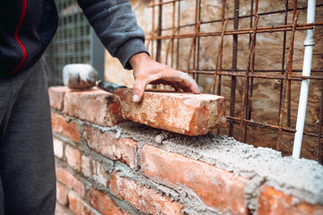 Close up of industrial bricklayer installing bricks on construction site. Construction works
