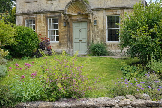 old english country house with flowers and lawn