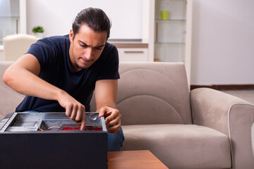 Young man repairing computer at home