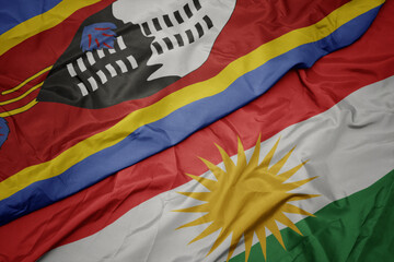 waving colorful flag of kurdistan and national flag of swaziland.