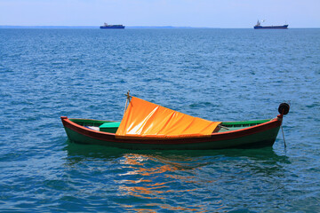  Greek traditional fish boat with yellow cover floating in the sea 