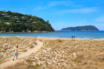 Pauanui Beach on the Coromandel Peninsula, New Zealand. To the left is Mount Paku and the town of Tairua. In the background is Shoe Island - obrazy, fototapety, plakaty