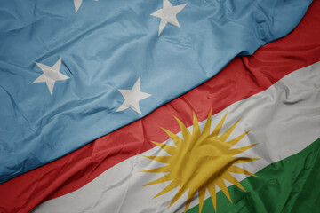 waving colorful flag of kurdistan and national flag of Federated States of Micronesia .
