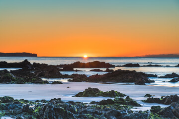 Fototapeta na wymiar Winter's Sunrise at Surf Beach with Craggy Rocks