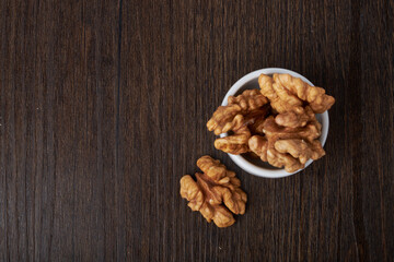 Walnut kernels on a wooden background.