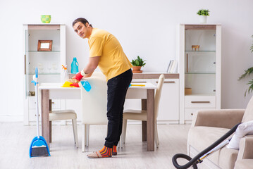Young male contractor cleaning the house