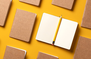 content marketing concept,.top view of hand writing on open notebook and yellow pencil align with kraft paper book in pattern on yellow table background.mockup for advertise content online - obrazy, fototapety, plakaty