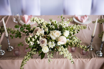 Top view of the presidium for the bride and groom with fresh white rose in restaurant. Close up luxury wedding banquet decor for newlyweds