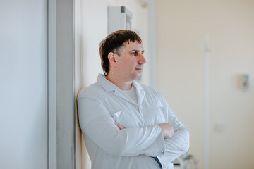 Fototapeta premium Adult handsome white doctor posing at white operation room. Copy space.