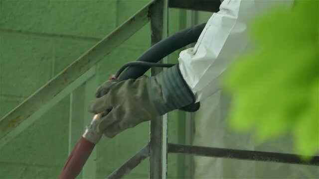 Close up from hand doing paint removing with sandblasting