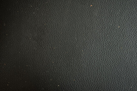 Dark black leather with brown spots texture background surface. Image for background. Selective focus applied.