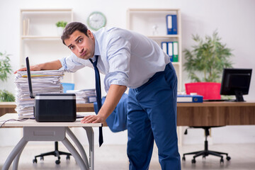Young male employee making copies at copying machine