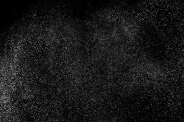 Abstract splashes of water on black background. Freeze motion of white particles. Rain, snow overlay texture.